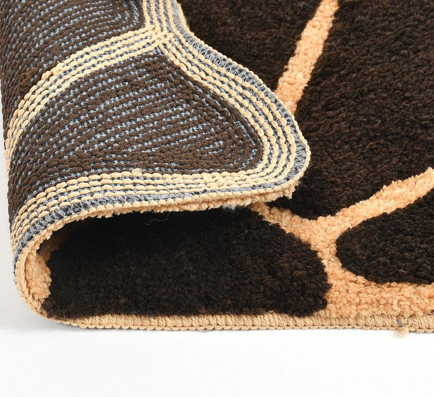 A close-up of the Supersoft Anti Skid Microfiber Doormat (45x70cms) Pack of 1 shows its black and beige textured design, with the mat partly folded to reveal the woven underside and stitched edge on a white background.